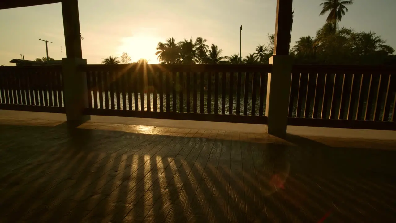 The suns sets beyond the village river and palm trees in Samutsongkram Thailand static time lapse