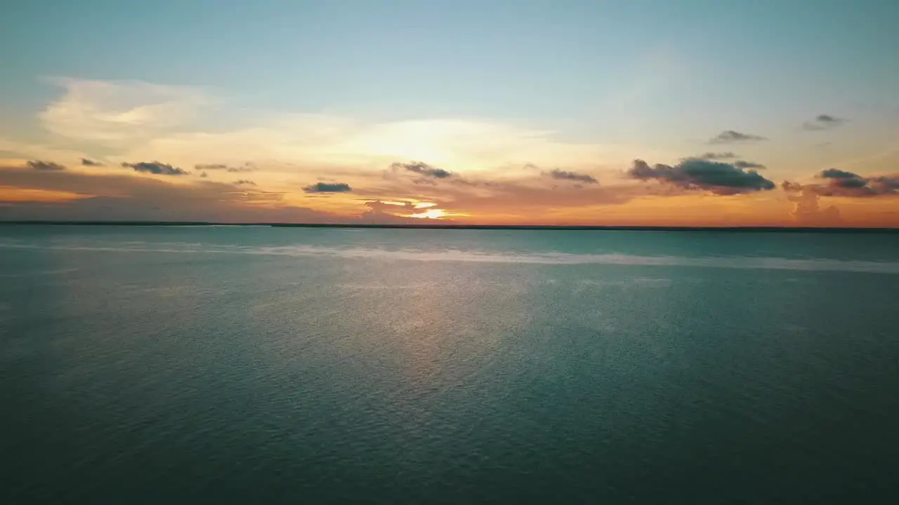 Unbelievable backwards slowly sinking drone shot of a perfect paradise sunset to a drem beach