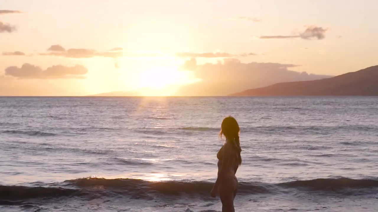 Caucasian blonde girl staring out at a beautiful sunset over the beach in Maui Hawaii