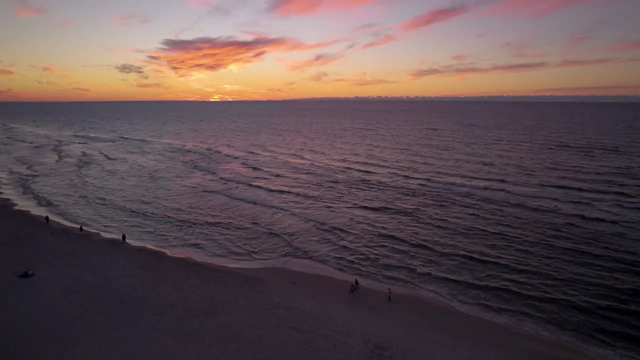 Idyllic Sunset View Over Seascape With People Strolling