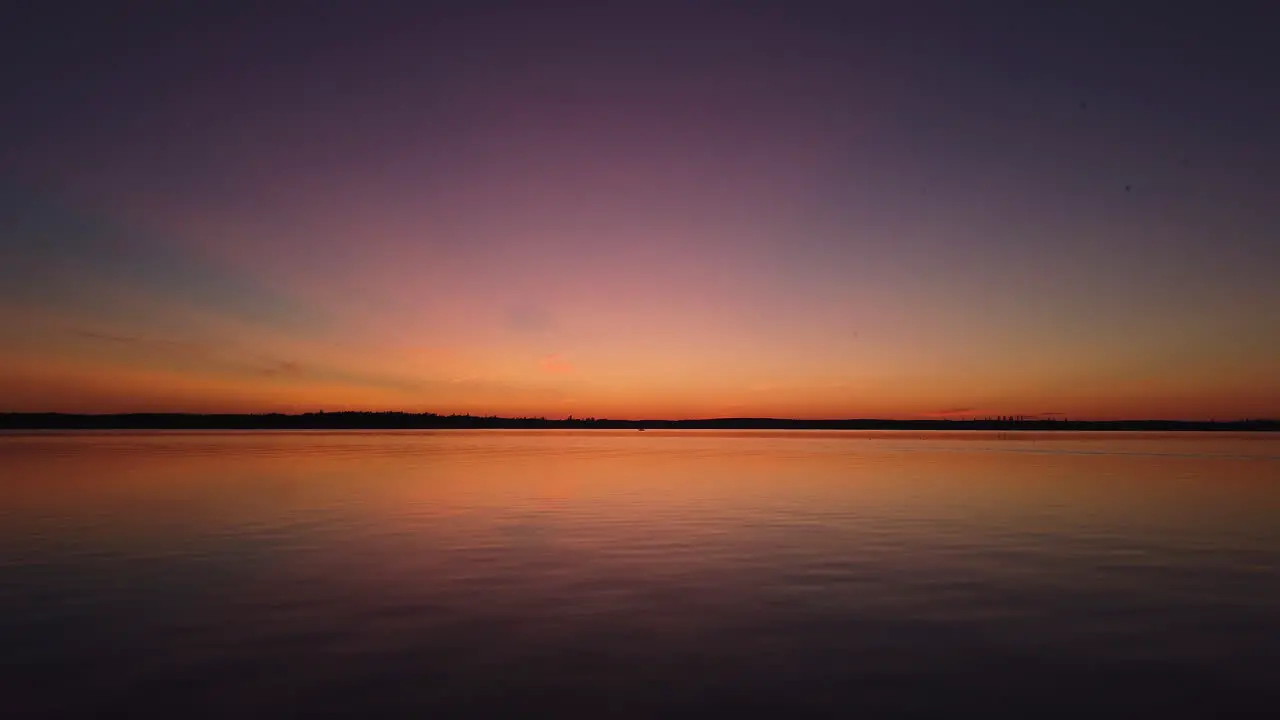 Aerial view of vibrant sunset over lake in Boreal Forest