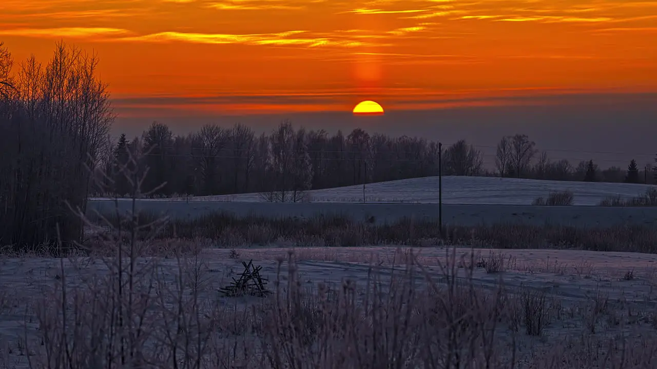 beautiful orange sunset timelapse background on snowy countryside meadow