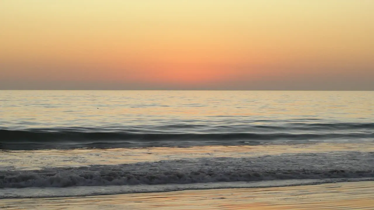 Lockdown shot of sunset over sea and waves on seashore