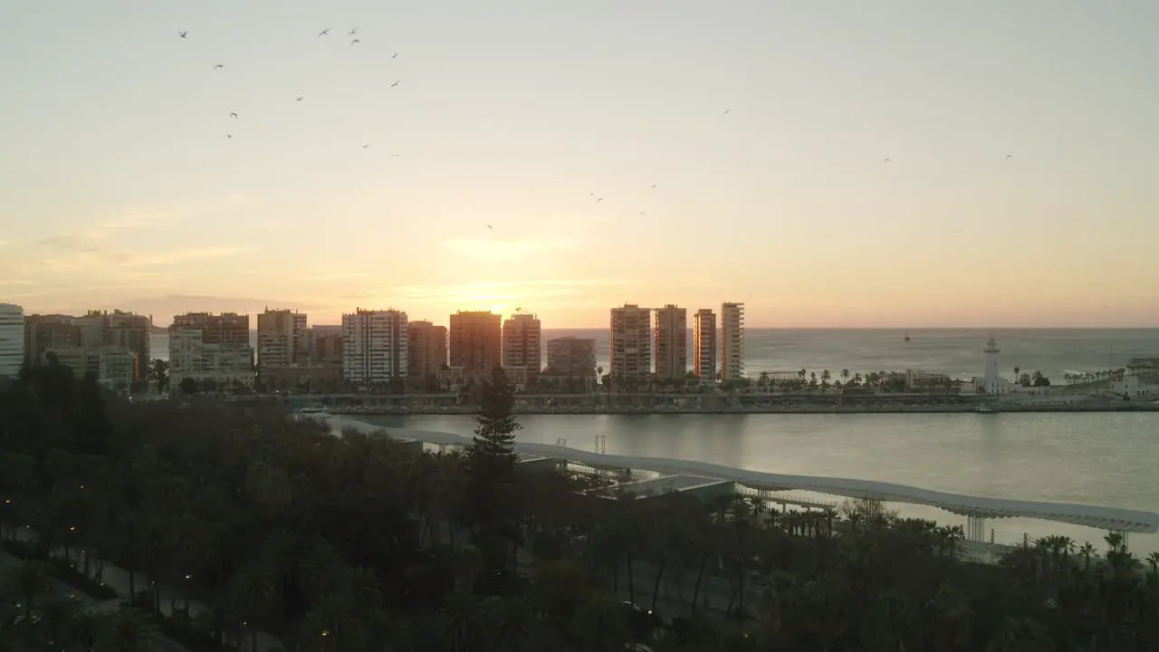 Aerial view showing silhouette of high rising apartments during beautiful sunset in the background