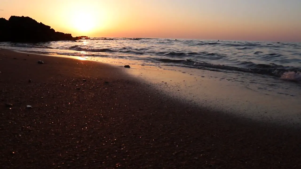 Calm ocean sea water waves breaking on sandy beach at sunset Tyre Lebanon static low angle