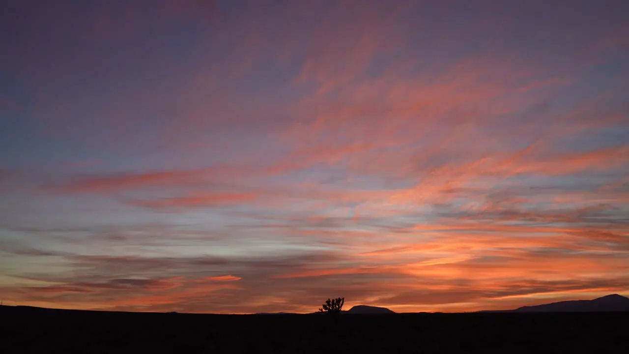 The setting sun paints with colorful romance across the Mojave Desert sky time lapse