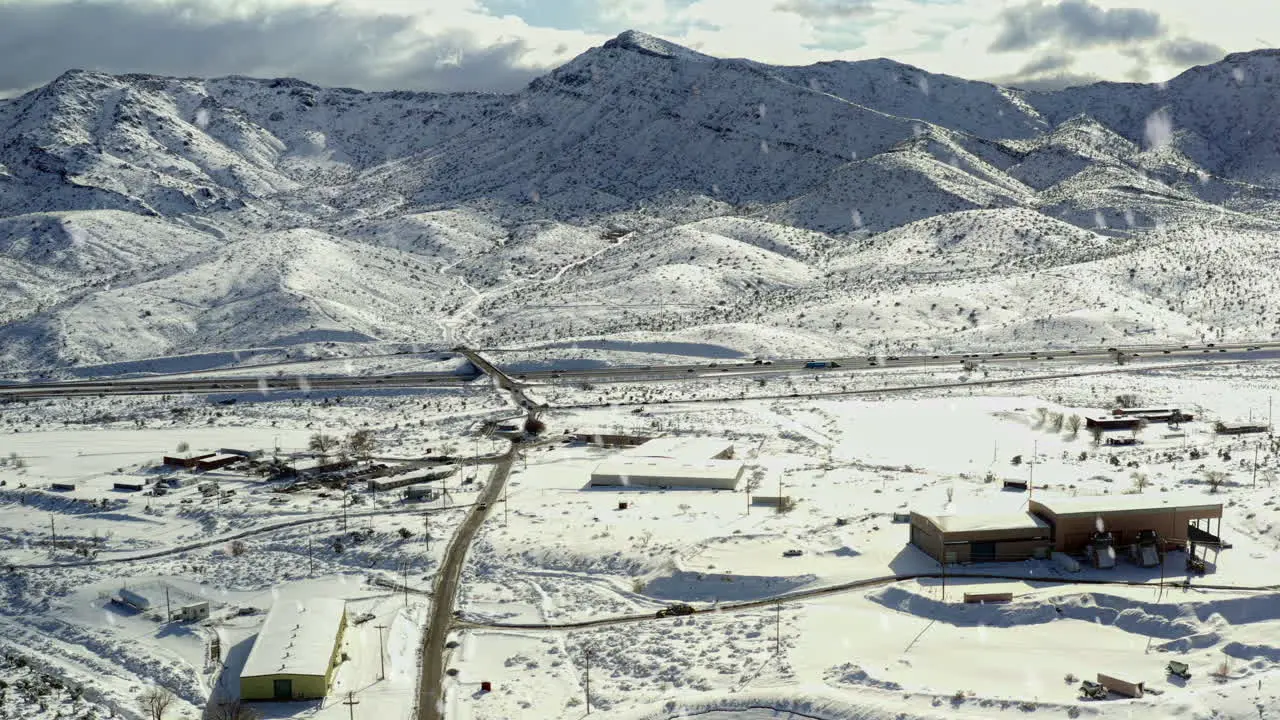 Aerial View of Snow Flakes Falling Down over Open Farmland of Northern California with Mountains in Distance