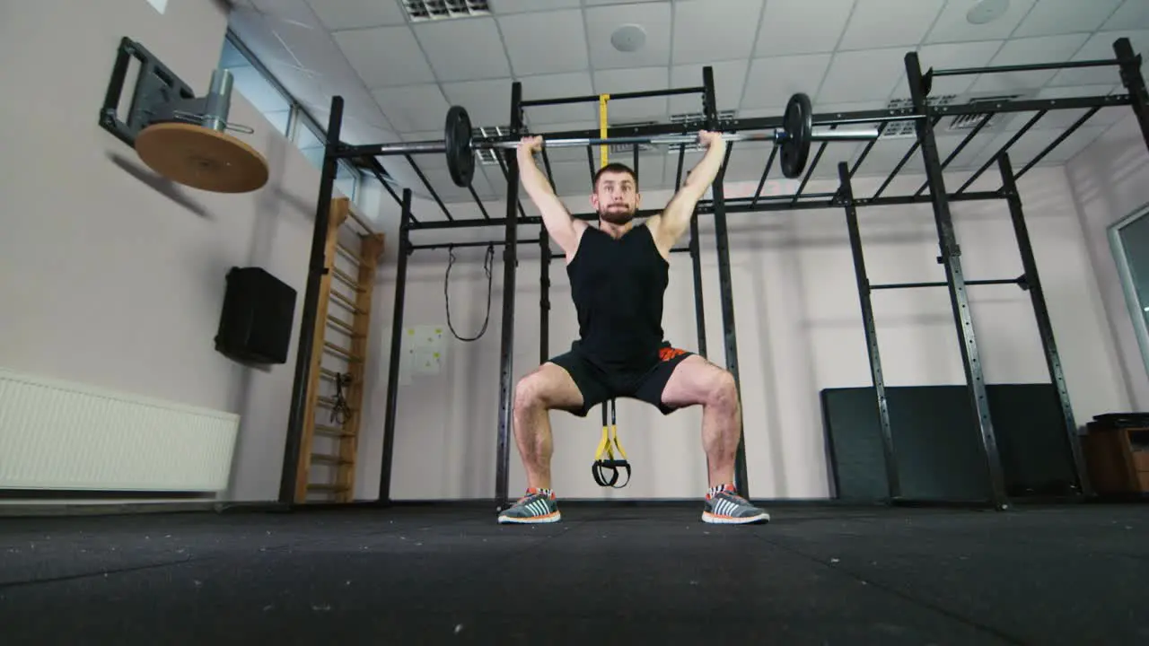 Athlete trains with a barbell in the gym 1