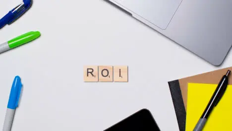 Stop Motion Business Concept Above Desk Wooden Letter Tiles Forming Acronym ROI 1