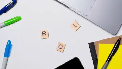 Stop Motion Business Concept Above Desk Wooden Letter Tiles Forming Acronym ROI