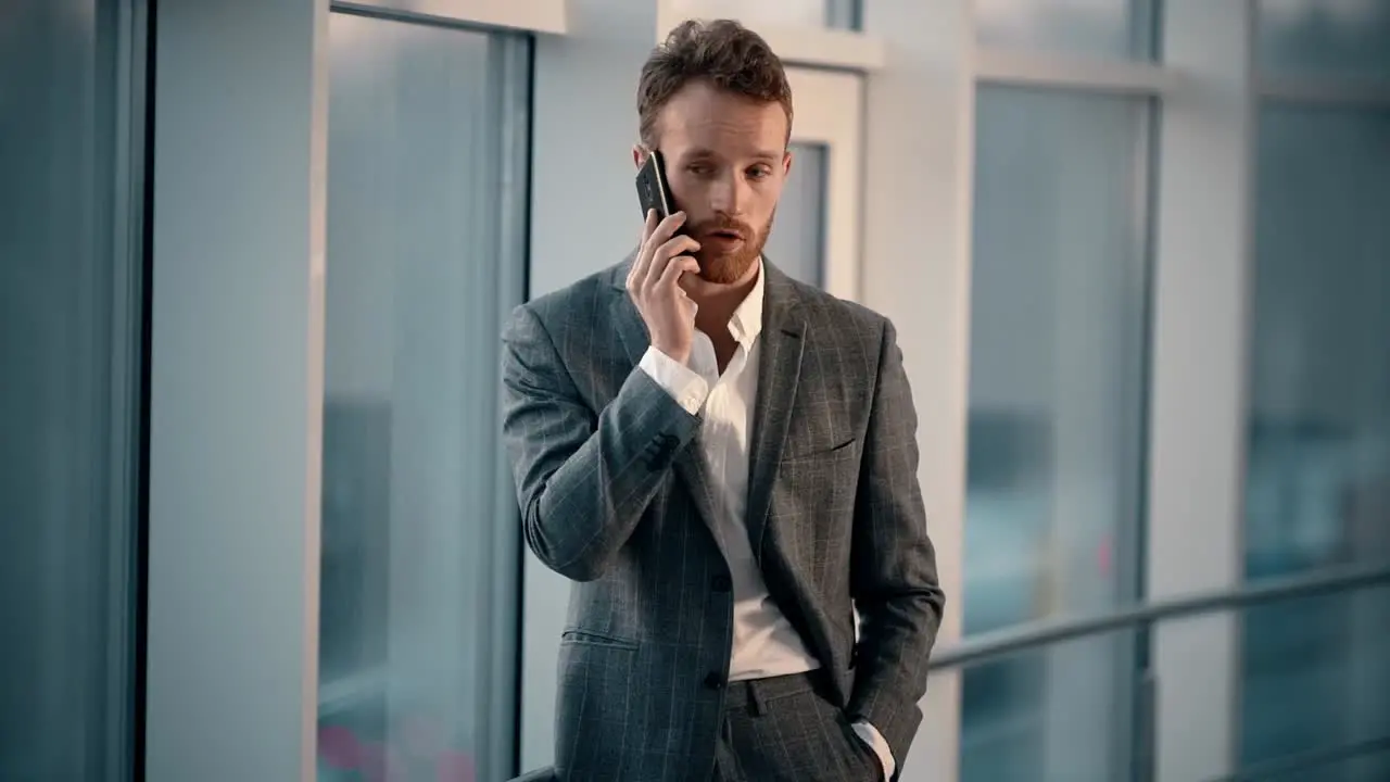 Happy young man in business suit talking on the phone on the background of the night city in the office