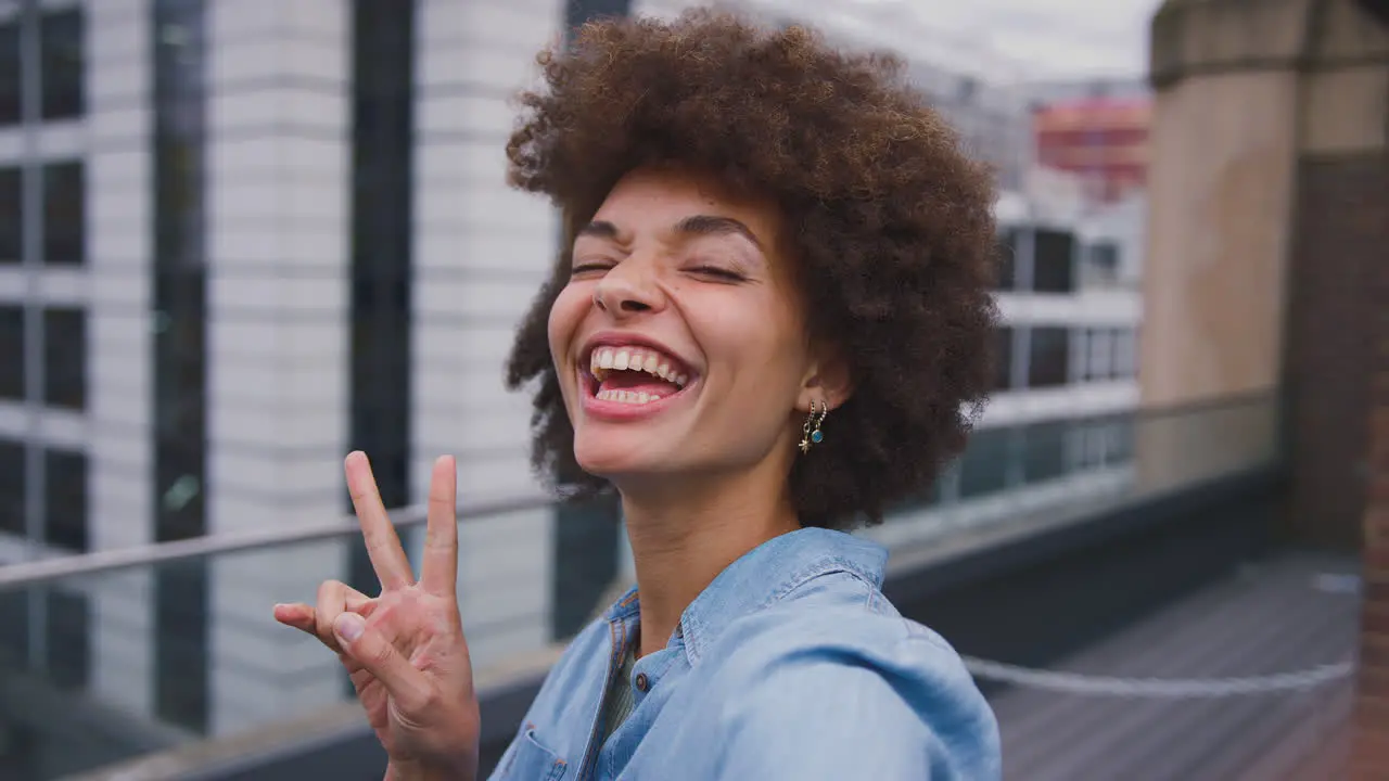 Portrait Of Smiling Young Businesswoman Posing For Selfie Standing Outside Modern Office