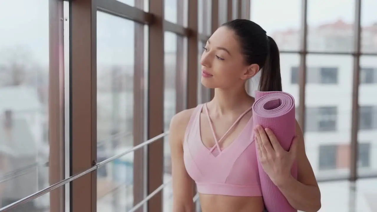 Beautiful girl with yoga mat goes to workout