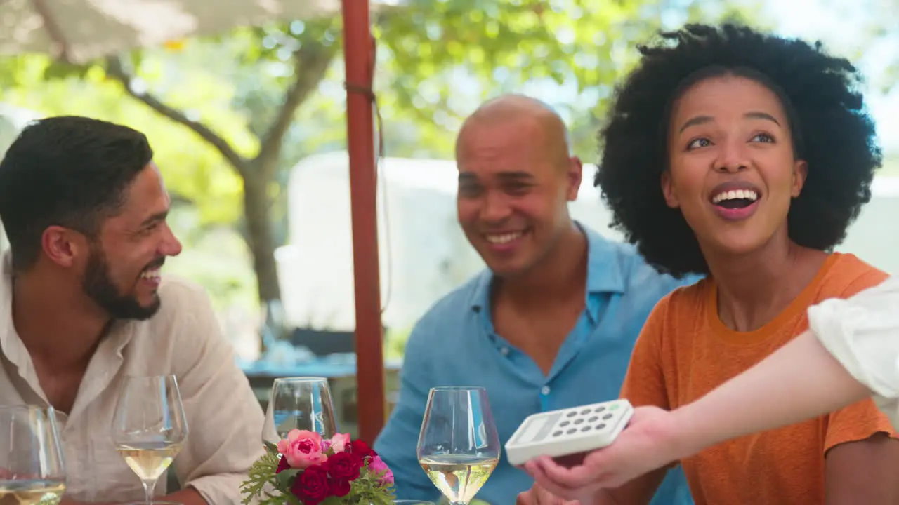 Woman Paying Bill At Outdoor Bar Or Restaurant Using Contactless App On Mobile Phone