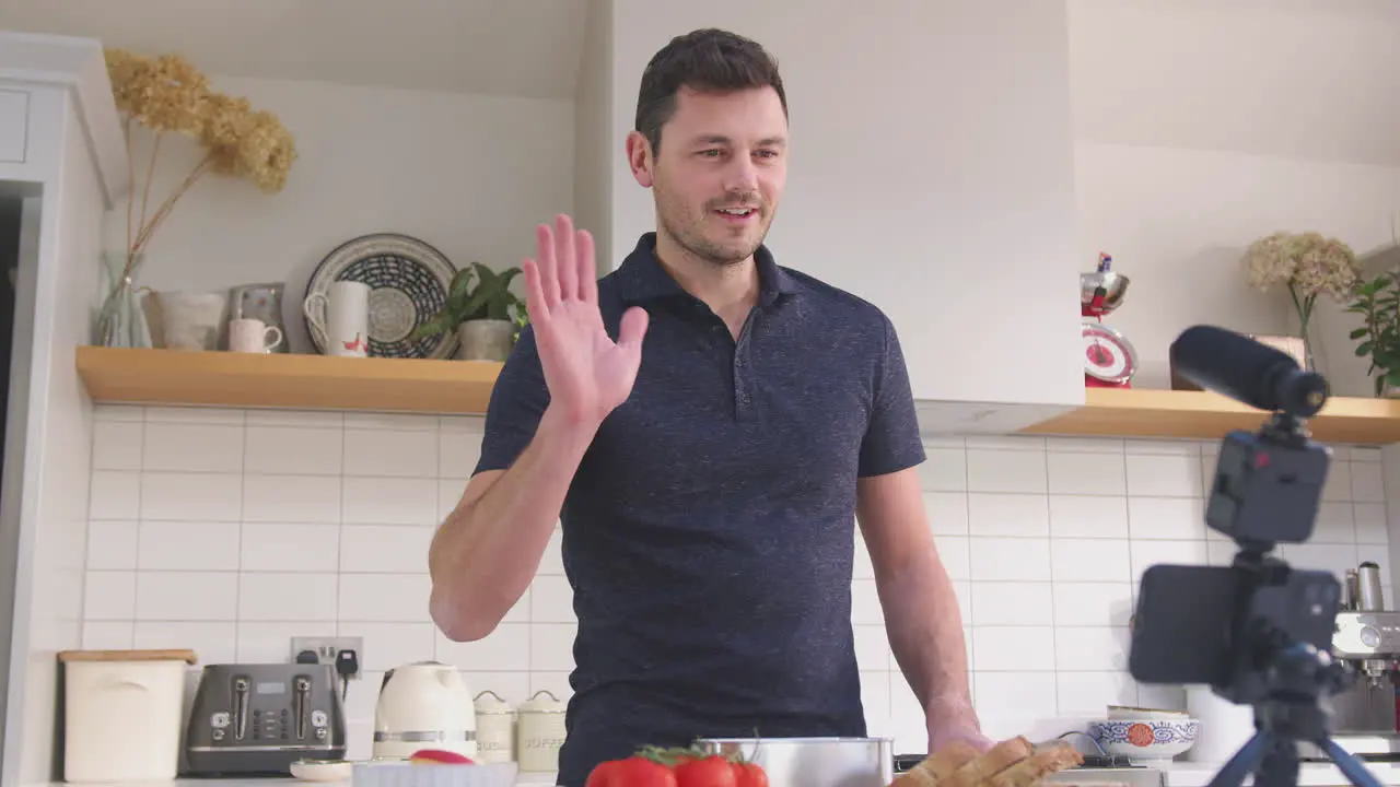 Mature man vlogging making social media video about food at home in kitchen on mobile phone shot in slow motion