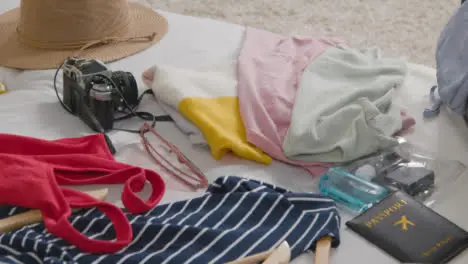 Close Up Of Open Suitcase On Bed At Home Being Packed For Summer Holiday 