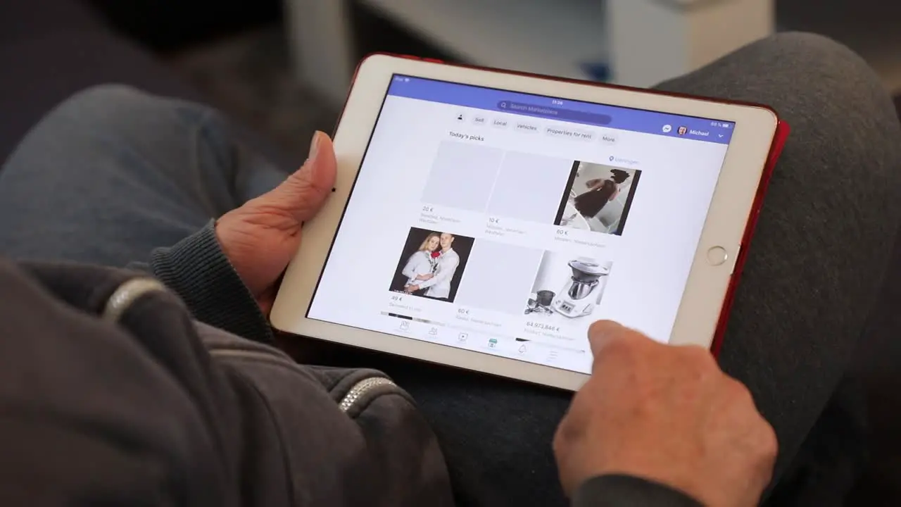 Mid adult man surfing the Facebook Market place in the app on an iPad in casual home environment