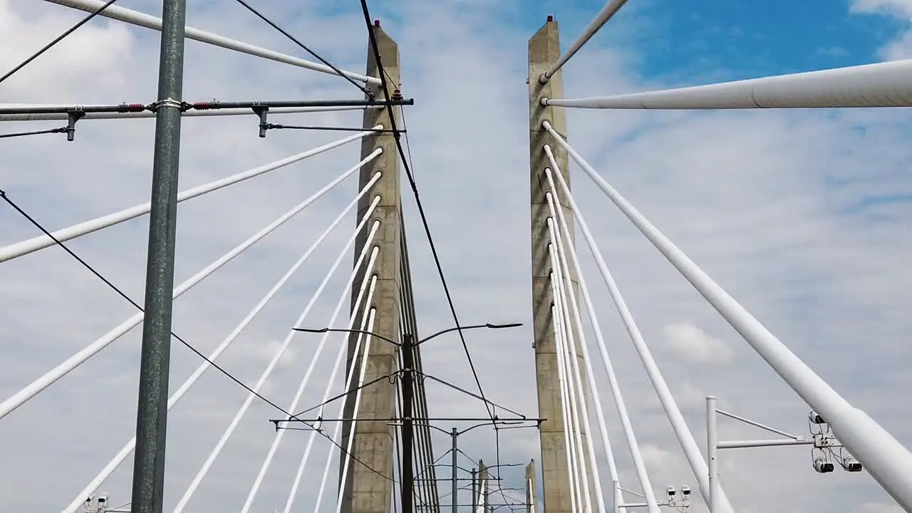 HD Looking up going across Tilikum Crossing Bridge in Portland Oregon showing part of the name on the bridge near end of clip with mostly cloudy sky take two