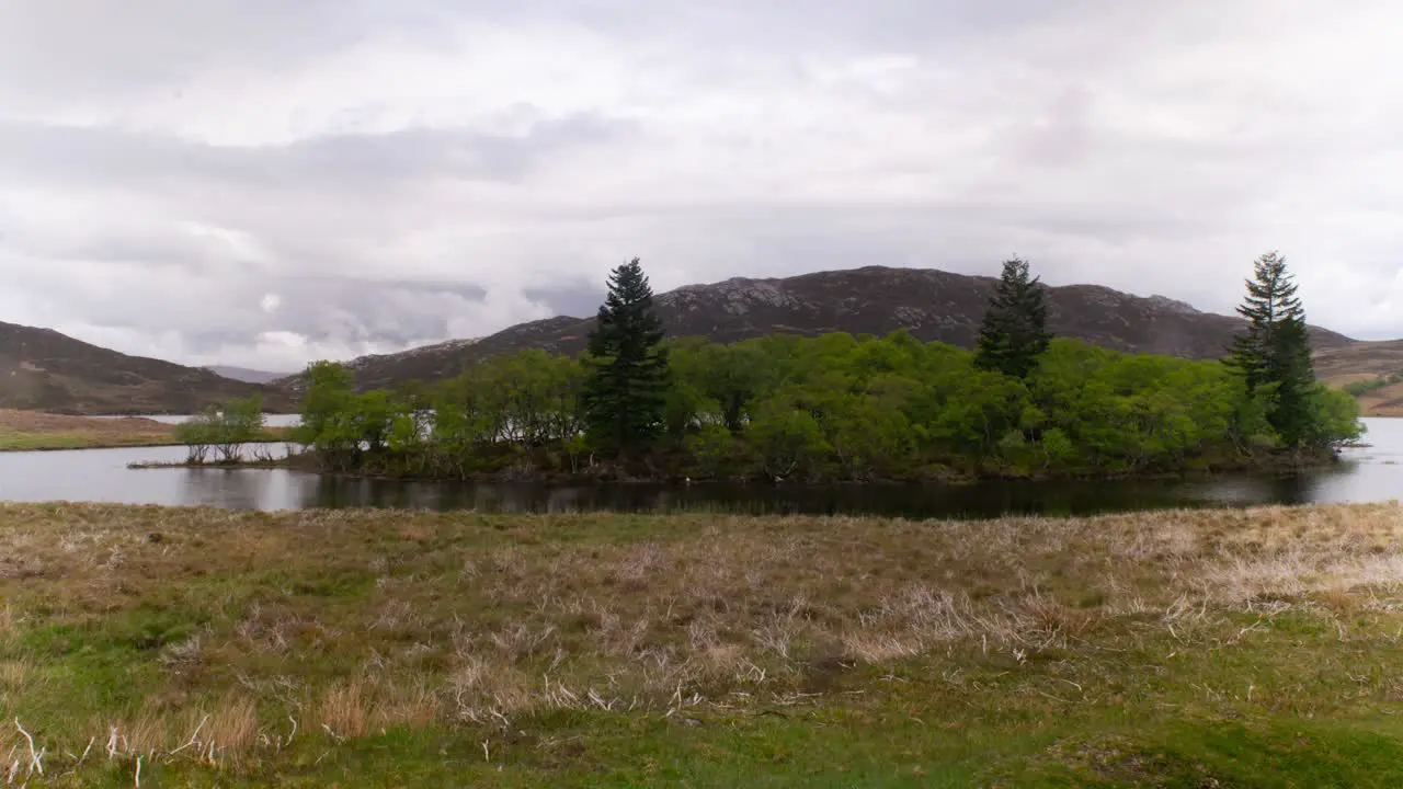 Cinematic timelapse of scottish lake with misty clouds in background