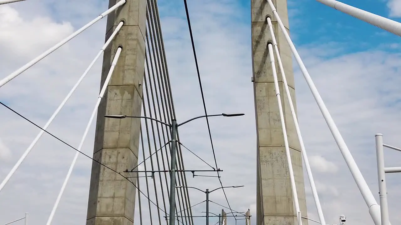 Looking up going across Tilikum Crossing Bridge in Portland Oregon showing part of the bridge name near middle of clip with mostly cloudy sky take three