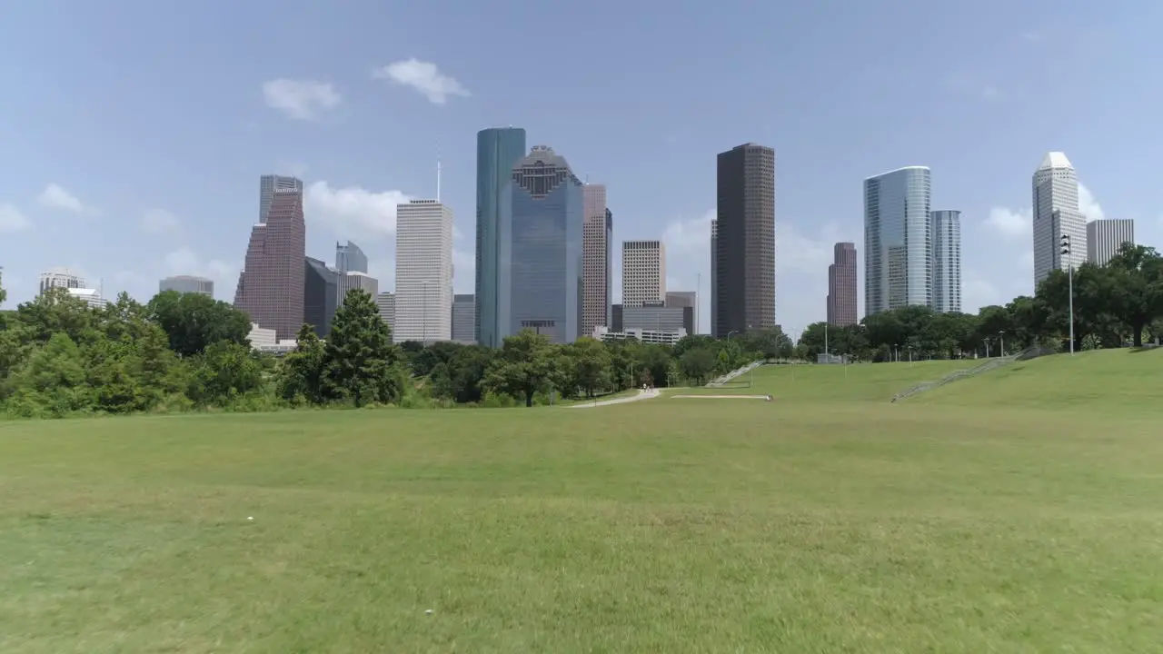 This video is about a low angle aerial view of downtown Houston from nearby park