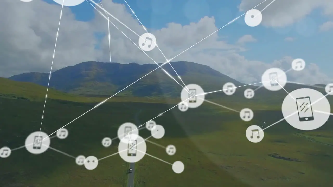 Animation of connected icons over green landscape against mountains and cloudy sky