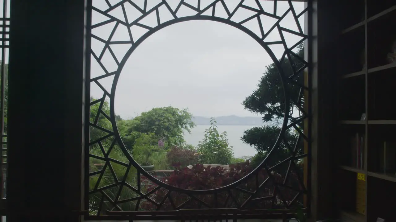 Circle shaped stylized window frame with the view on the forest and ocean down below on a cloudy day