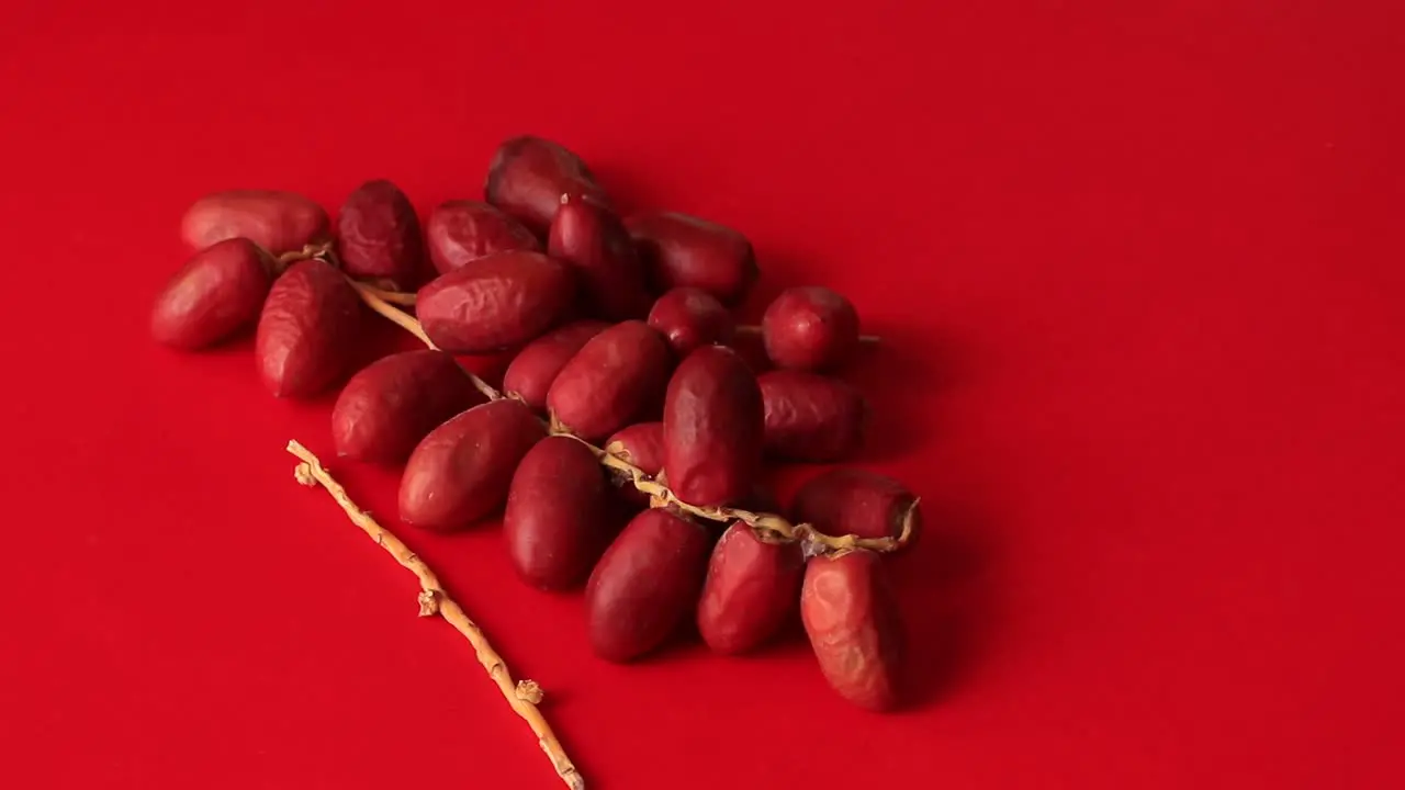 A bunch of ripe Indian dates on a red background