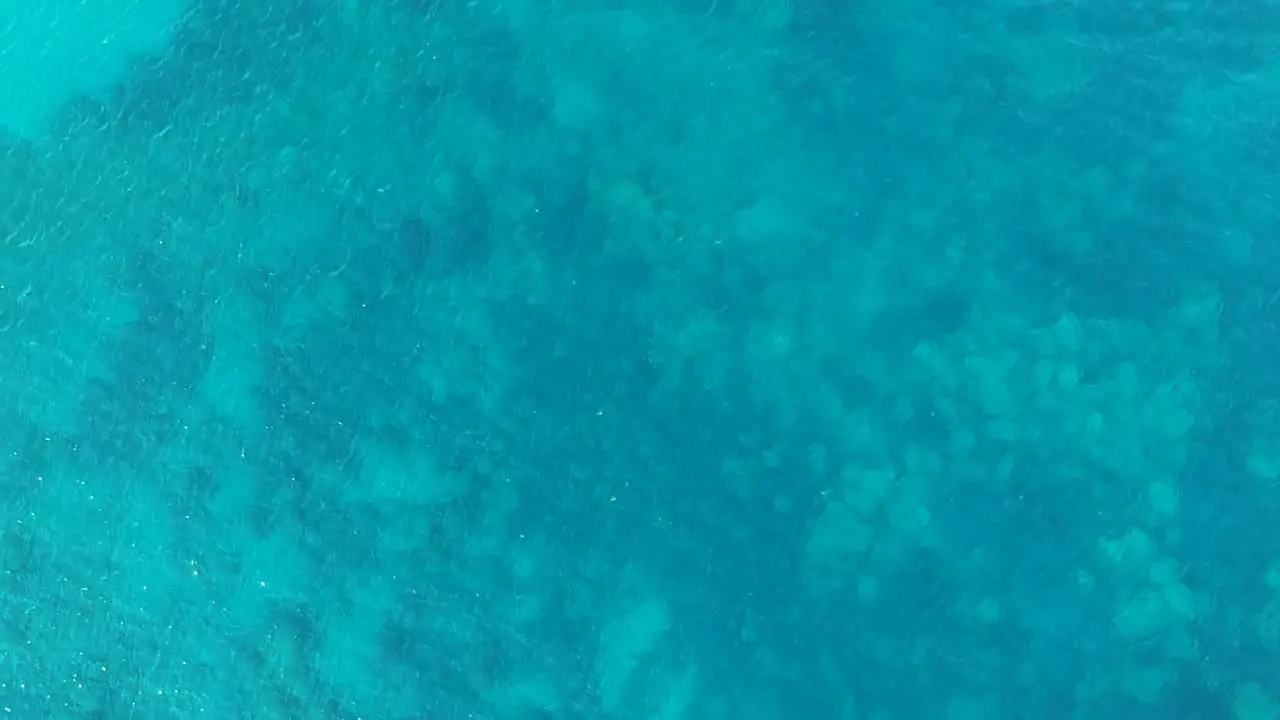 Turquoise blue water with coral reefs below on the island of Zakynthos Greece Aerial drone lift view from above