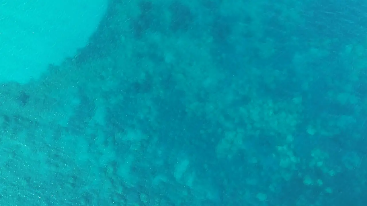 Clear turquoise blue water with coral reefs below on the island of Zakynthos Greece Aerial drone lift view from above