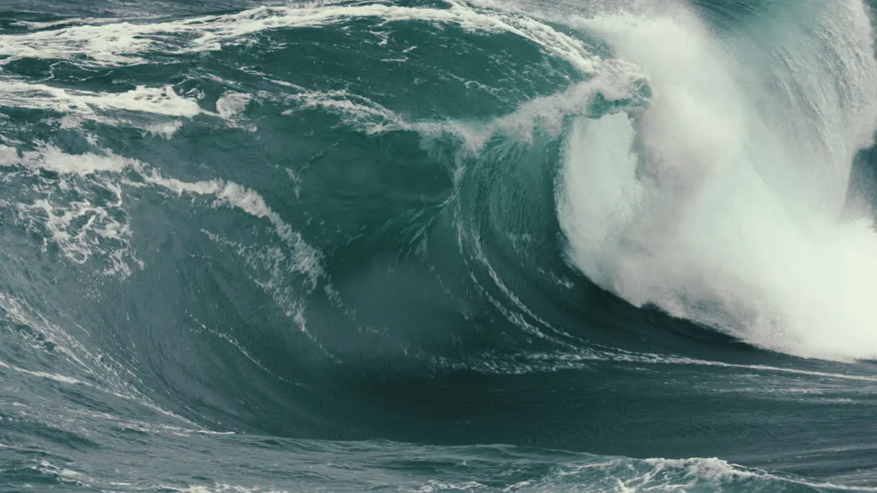 Foamy wave breaking in slow motion close to rocks