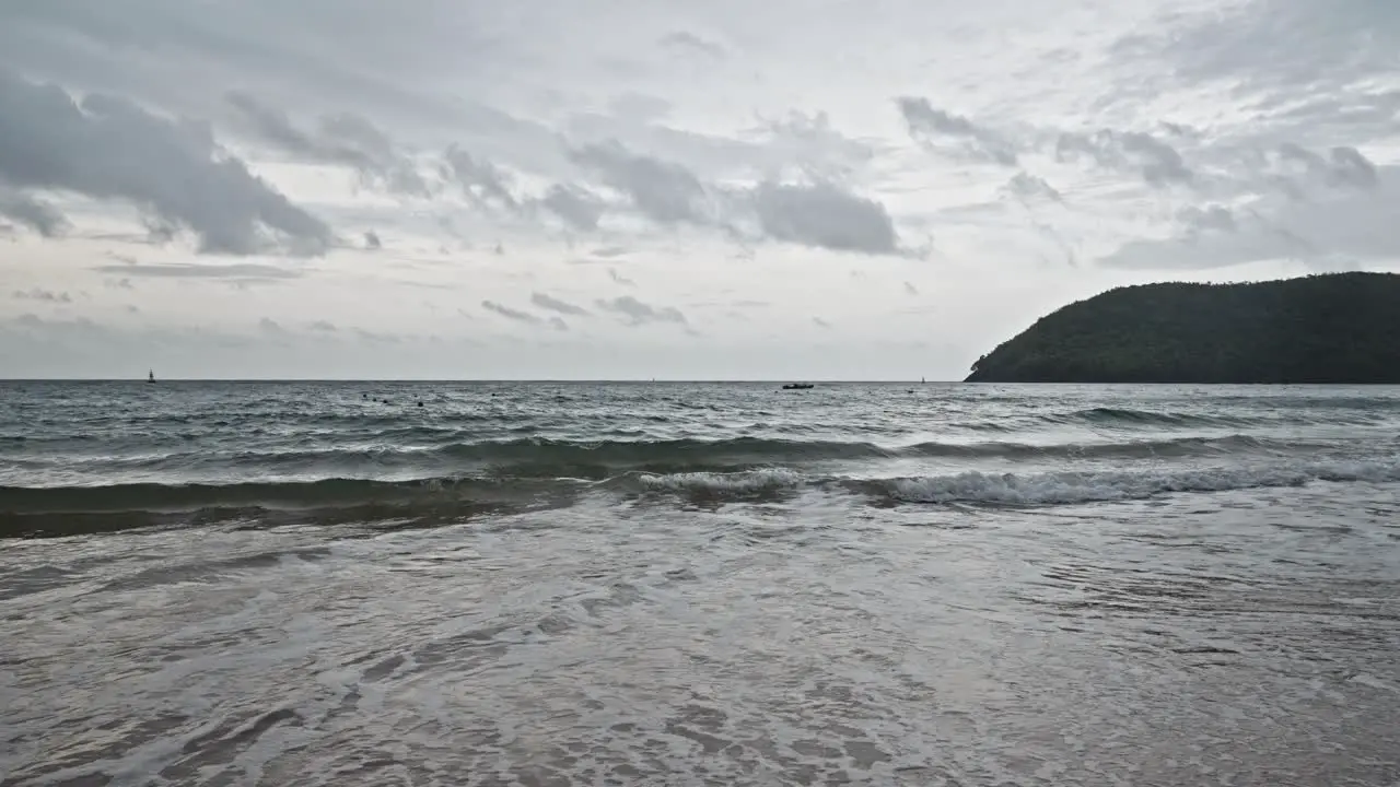 dramatic desaturated waves crashing on a sandy beach under a captivating sky