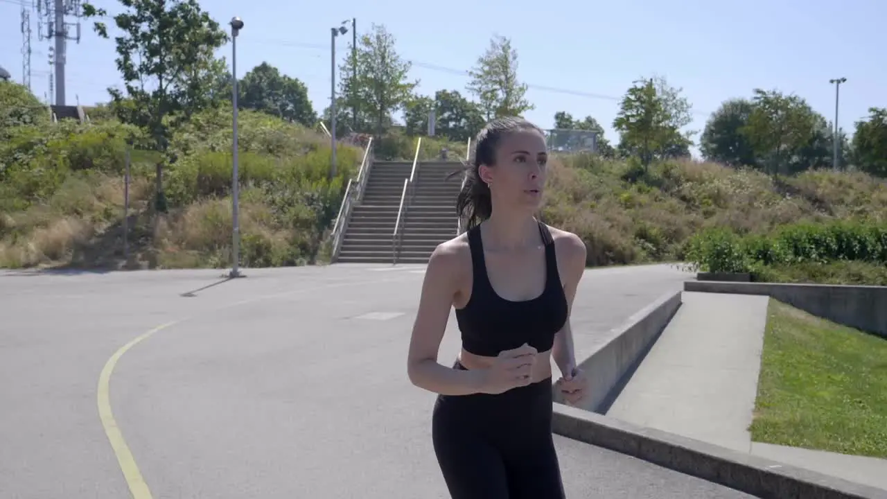 Sporty Girl Running Outdoors on a Sunny Day Slow Motion Follow Shot