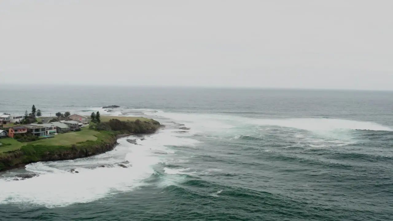 Aerial drone shot flying towards and around Gerroa headland on a stormy day in south coast NSW Australia