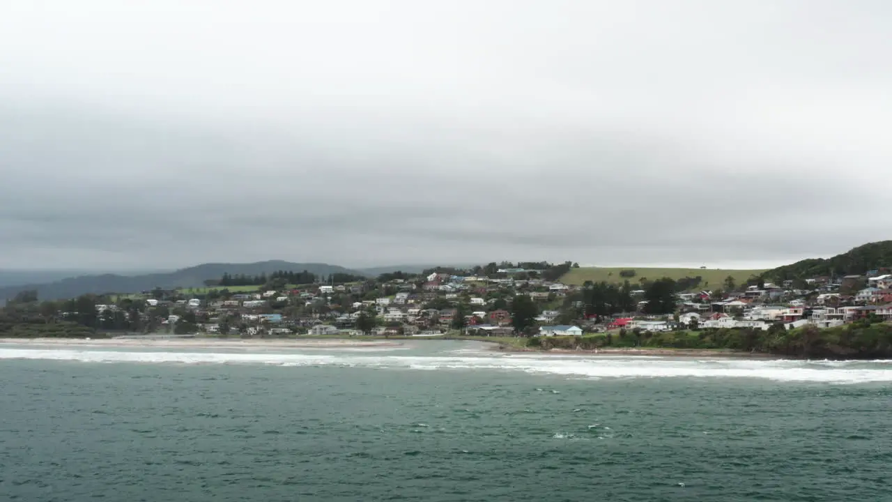 Aerial drone shot flying over the ocean towards Gerroa on a stormy day in the south coast of NSW Australia