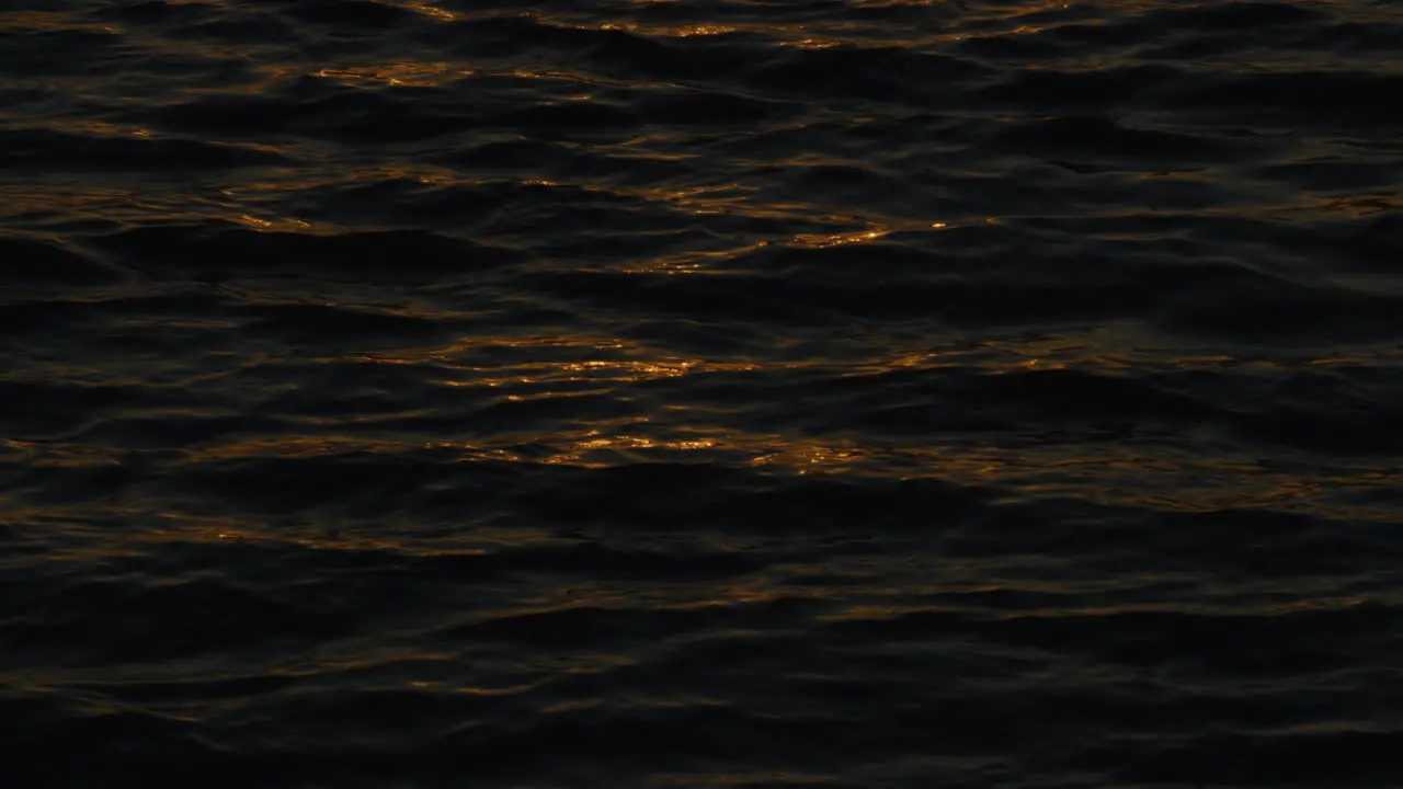 Meditative Waves With Golden Orange Sunset Light Reflected In The Ripples