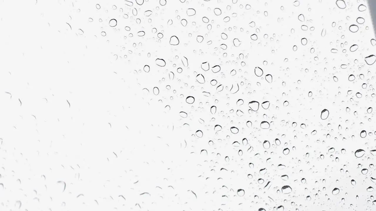 Water droplets falling on a car glass