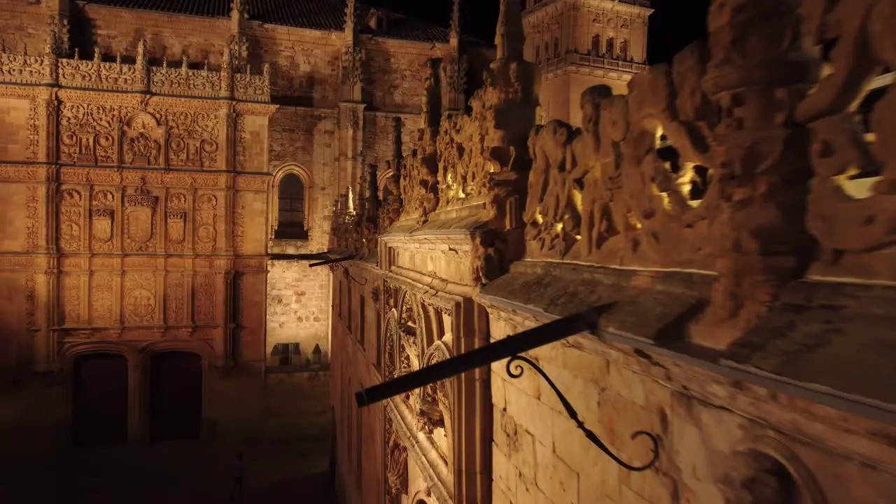 Following the edge of the facade of a neoclassical heritage building in Salamanca Spain at close distance illuminated at night