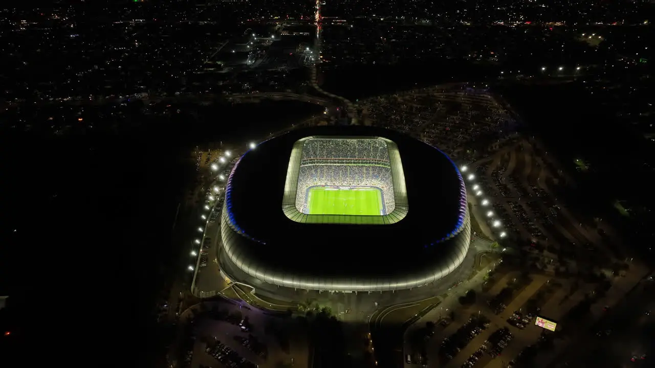 Drone shot tilting over the night lit BBVA stadium in Monterrey city Mexico