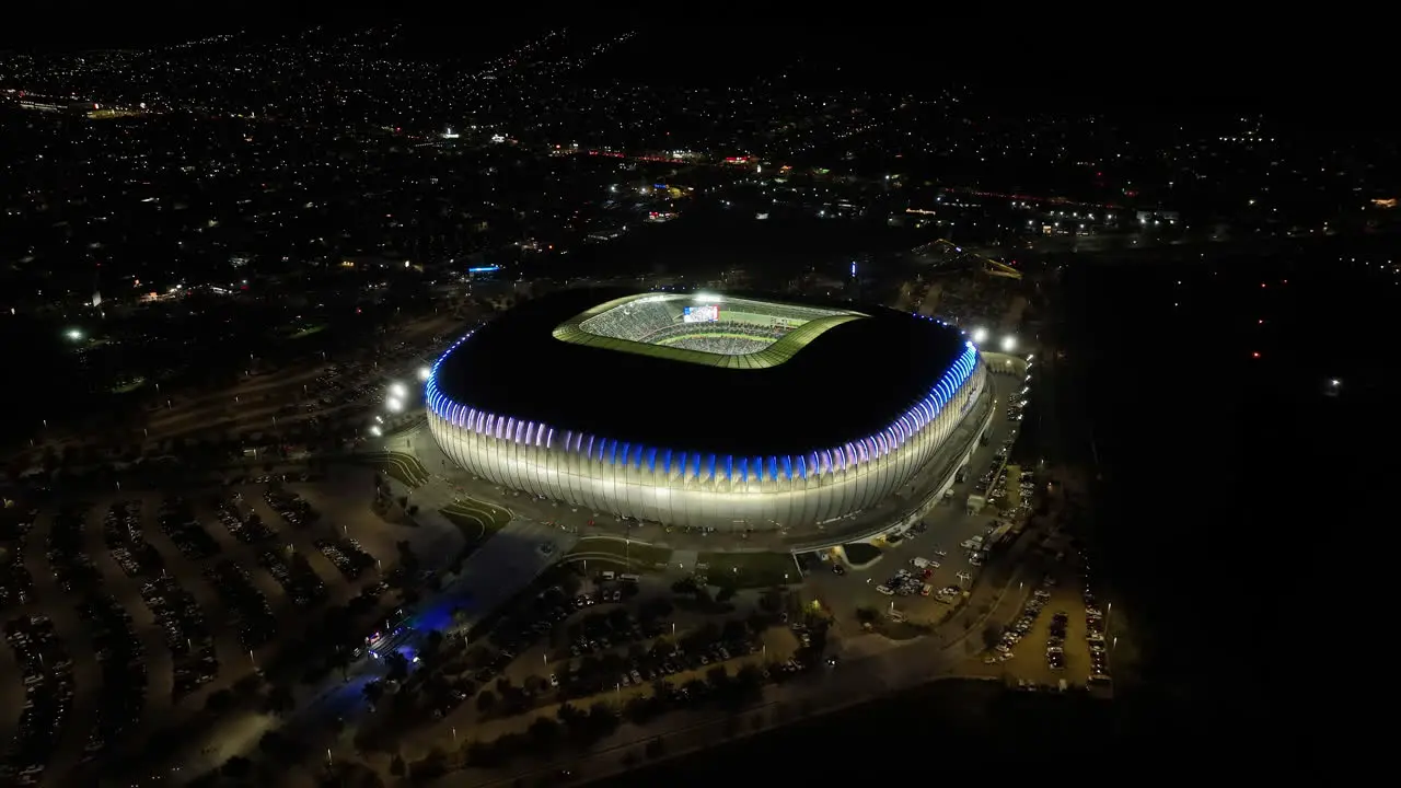 Aerial view away from the BBVA stadium night in Monterrey Mexico reverse tilt drone shot