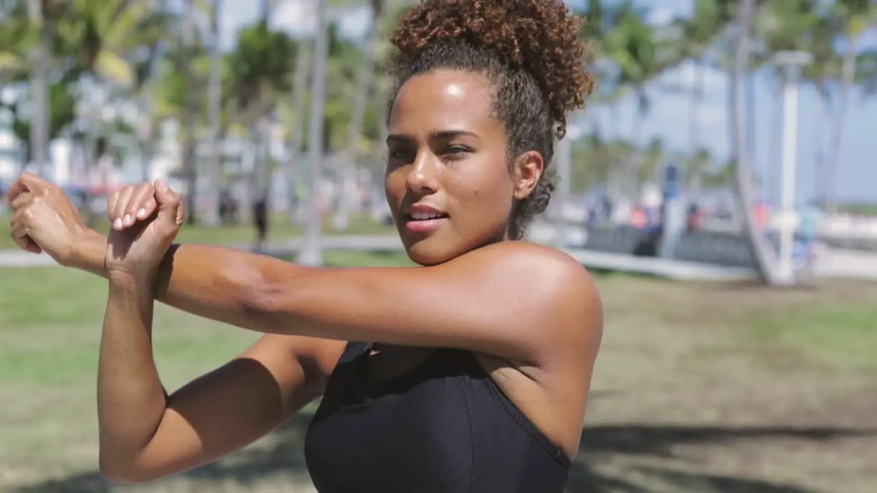 Woman stretching arm in park