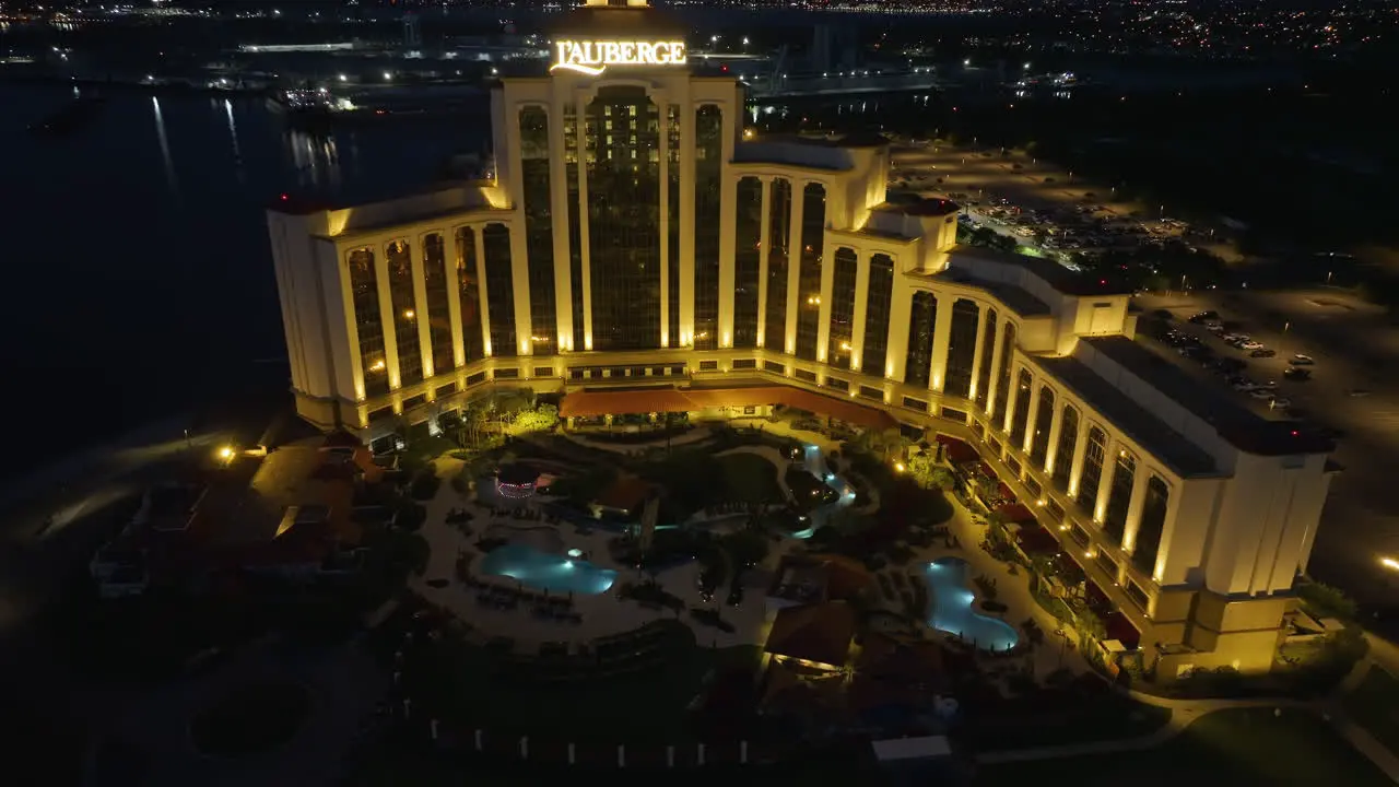 Drone shot around the pool area in front of the L'Auberge Casino and Hotel night in Lake Charles Louisiana USA