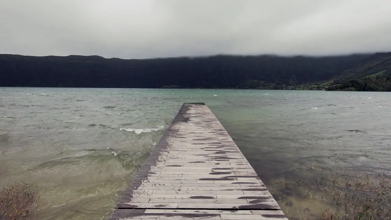 POV shot of walking on a small wooden pier by the lake