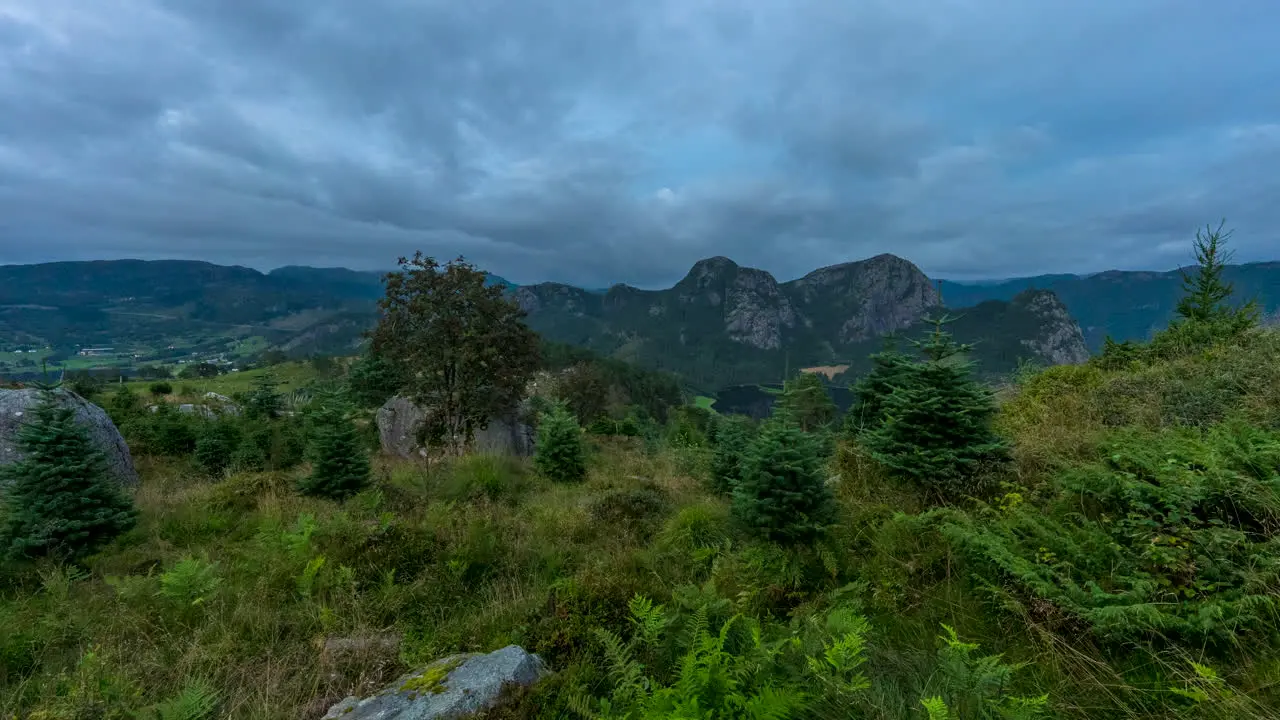 Overcast clouds roll over green nordic mountain landscape timelapse