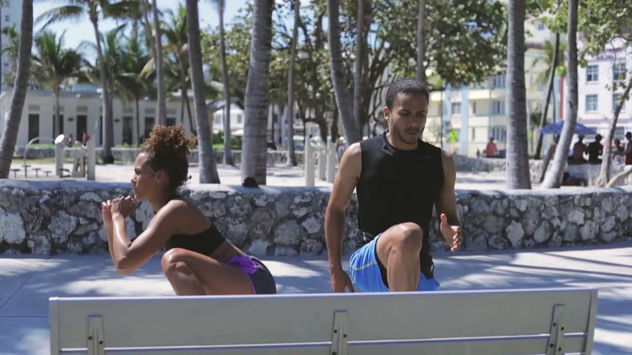 Couple standing and working out at bench