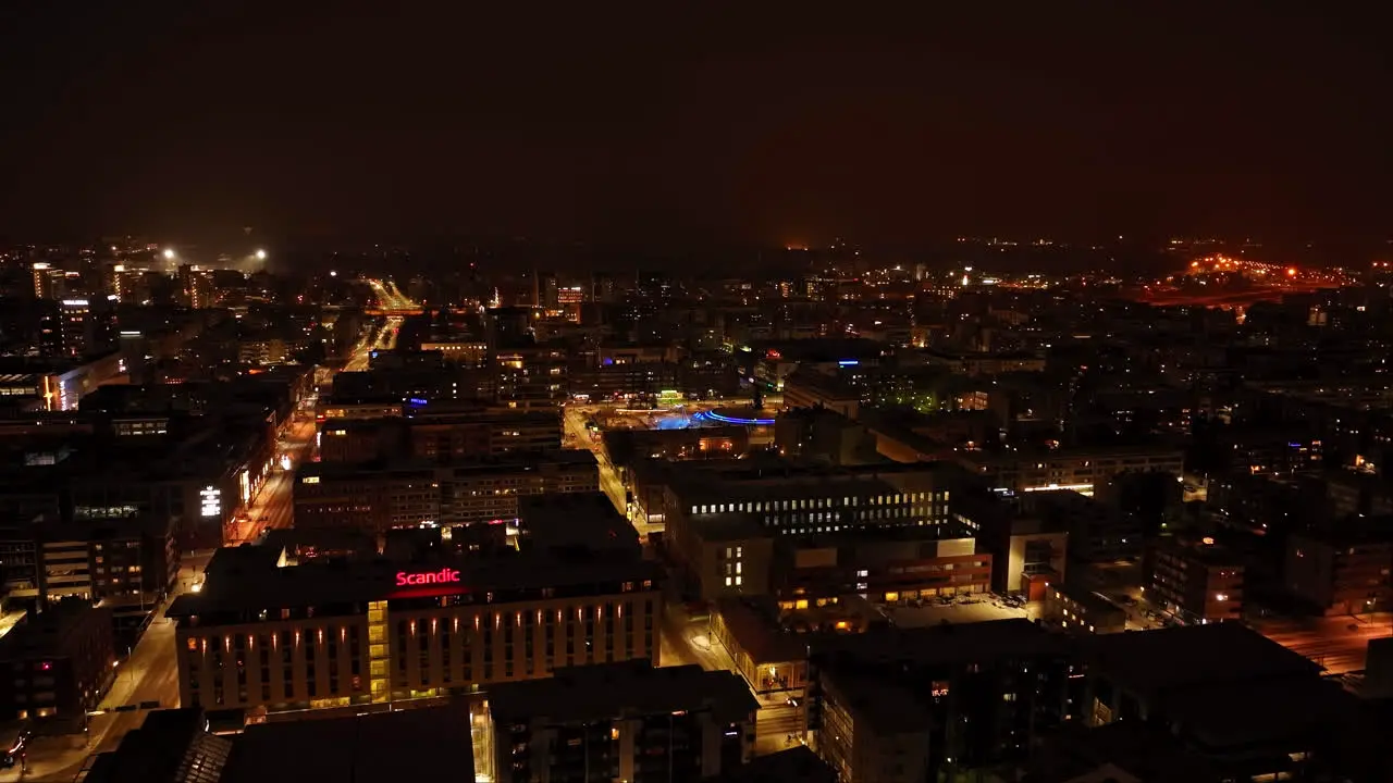 Flying over the night lit streets of downtown Oulu winter in Finland Aerial view