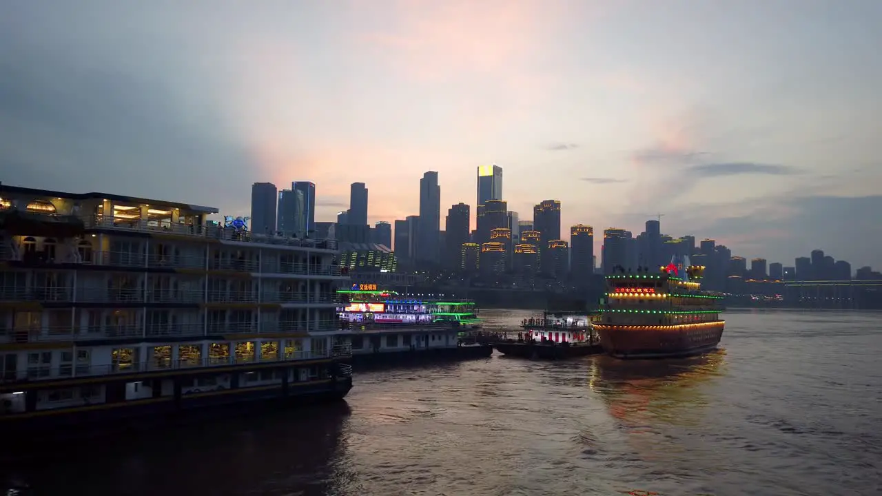 Tourist sightseeing ship cruising on the confluence of Yangtze and Jialing rivers in Chongqing town at dusk