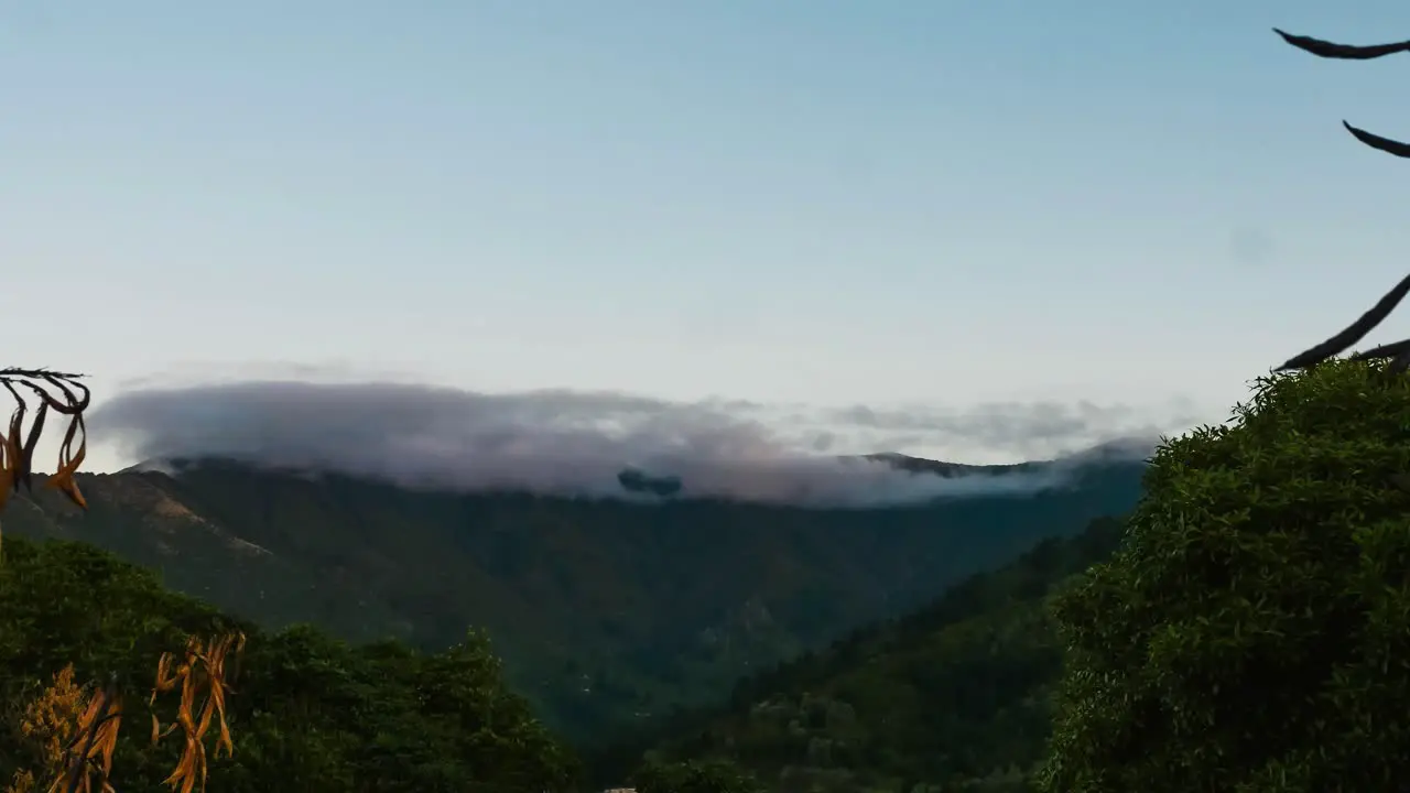 ROLLING CLOUDS OVER MOUNTAIN AS SUN SETS TIMELAPSE