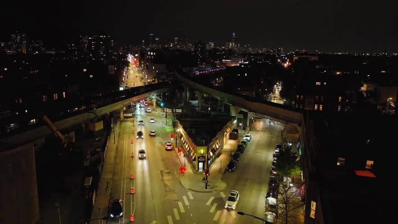 Static drone shot of elevated railway crossing above the illuminated streets of Wrigleyville Chicago