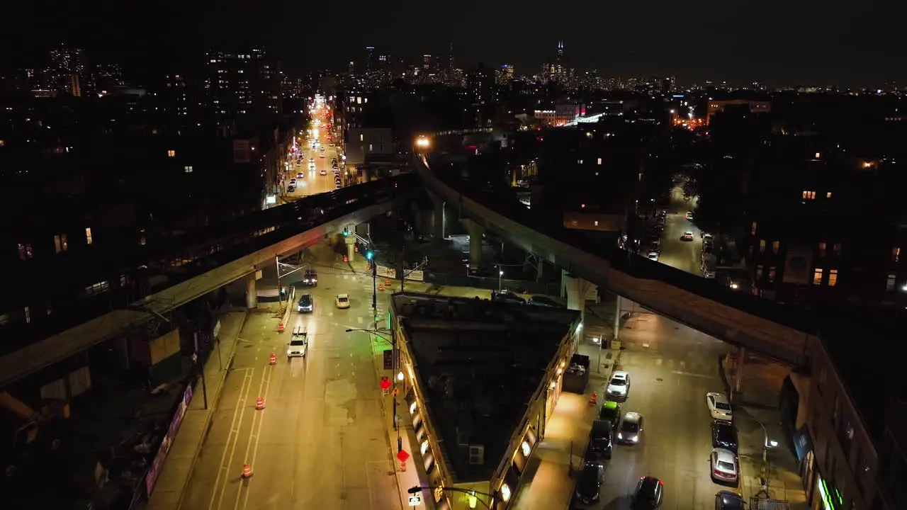 Aerial view of a train crossing rails above the night lit streets of Chicago